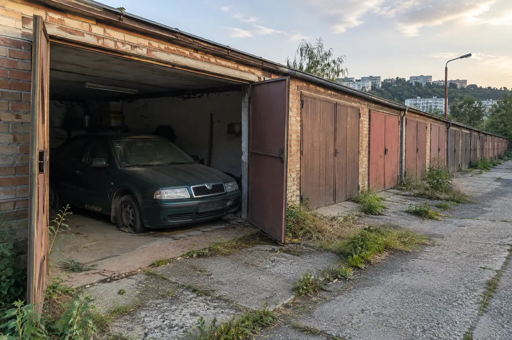 Zaprášená zelená Škoda Octavia stojí roky v garáži v garážové kolonii v Motole